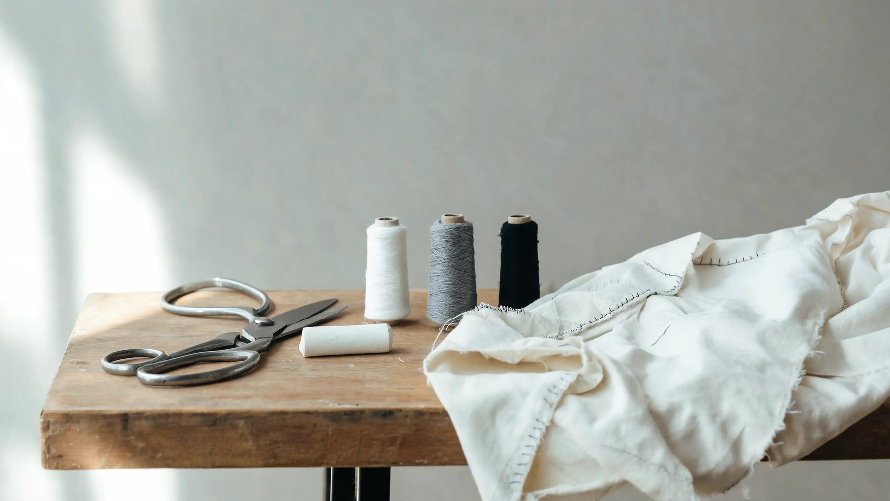 Workroom bench with shears, chalk and thread